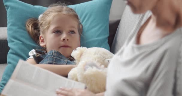 Pretty girl fell asleep while her mother reading book — Stock Video