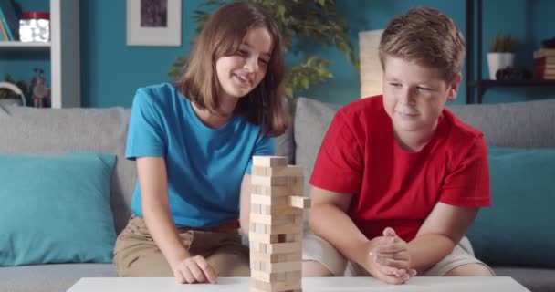 Fröhlich Bruder und Schwester spielen zu Hause mit Holzspielzeug — Stockvideo