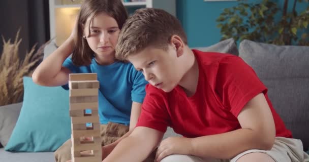 Pretty girl and boy using wooden blocks for playing at home — Stock Video