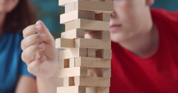 Agradable chica y niño jugando juntos con ladrillos de madera — Vídeos de Stock