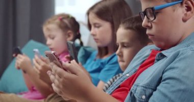 Boş zamanlarında akıllı telefon kullanan bağımlı çocuklar.