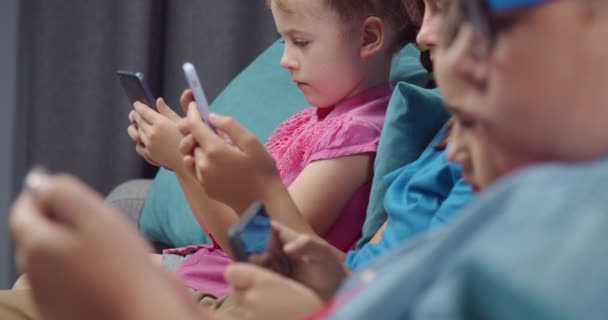 Empat teman kecil bermain sendiri smartphone dalam keheningan — Stok Video