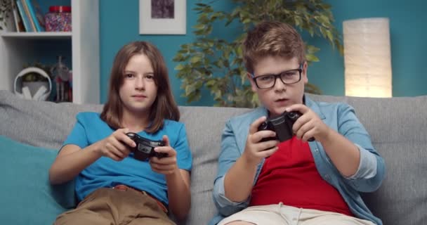 Ragazzo e ragazza sul divano con joystick che falliscono nei videogiochi — Video Stock