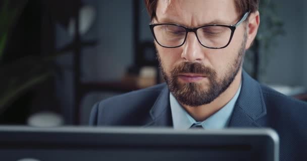 Blisko skupiony mężczyzna w okularach pracuje na komputerze — Wideo stockowe
