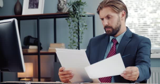 Empresário barbudo que examina documentos no local de trabalho — Vídeo de Stock