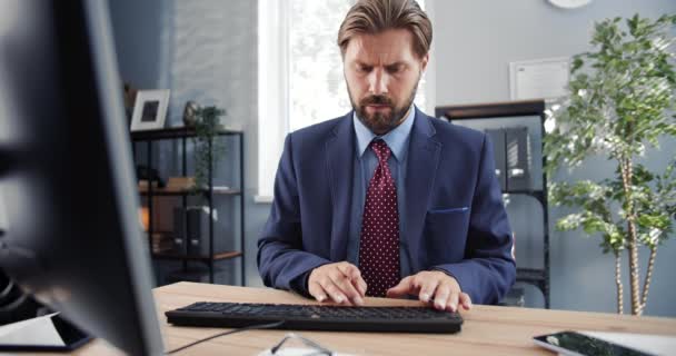 Frontansicht eines seriösen Mannes im Anzug, der am Computer arbeitet — Stockvideo