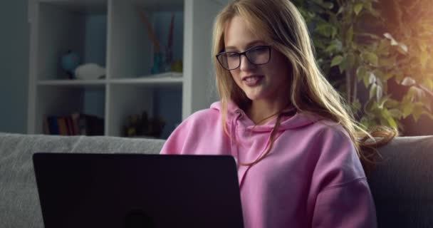 Charmante fille dans les lunettes ayant chat vidéo sur ordinateur portable — Video