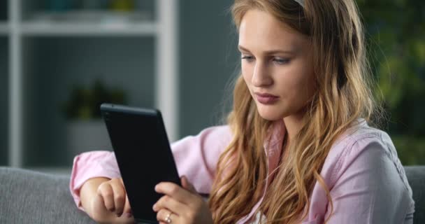 Superbe femme utilisant une tablette pour les réseaux sociaux à la maison — Video