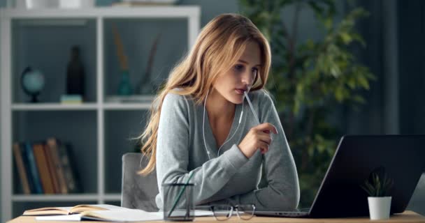 Menina focada em fones de ouvido usando laptop para estudar em casa — Vídeo de Stock