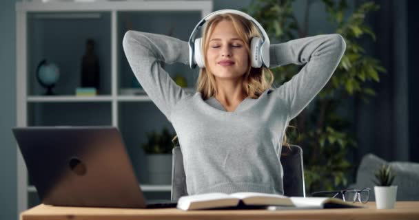 Menina feliz em fones de ouvido ouvir música em casa — Vídeo de Stock