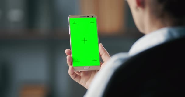 女性はオフィスでスマートフォンの緑の画面を見て — ストック動画