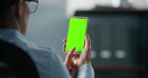 Mujer sosteniendo móvil y golpeando con el dedo en la pantalla verde — Vídeos de Stock