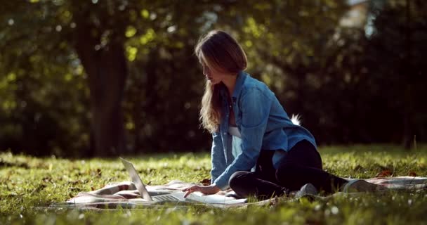 Mulher bonita usando laptop para estudar no parque — Vídeo de Stock
