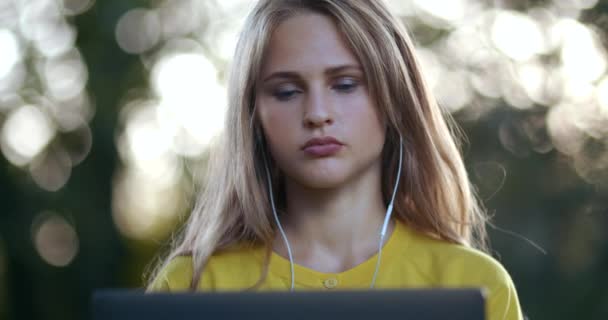 Junge Frau benutzt Laptop für Videochat auf Laptop im Park — Stockvideo