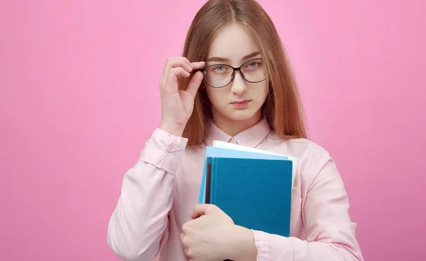 Estudiante sosteniendo libros tocando gafas — Foto de Stock