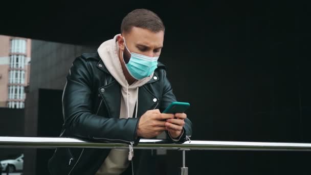 Homme dans le masque tenant smartphone — Video