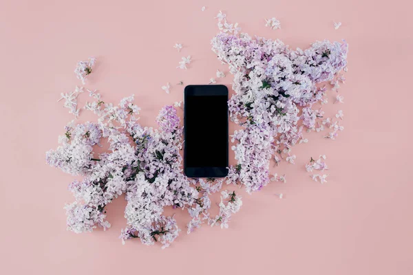 Slimme Telefoon Met Een Boeket Van Seringen Roze Achtergrond Plat — Stockfoto