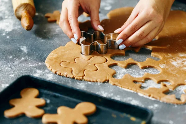 Christmas food concept. Woman is cooking gingerbread man cookies in Christmas close up. Xmas dessert