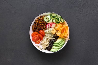 Vejetaryen Buda kase. Temiz ve dengeli sağlıklı gıda kavramı. Pirinç, baharatlı nohut, siyah ve beyaz quinoa, avokado, havuç, kabak, turp, domates koyu arka plan, üstten görünüm