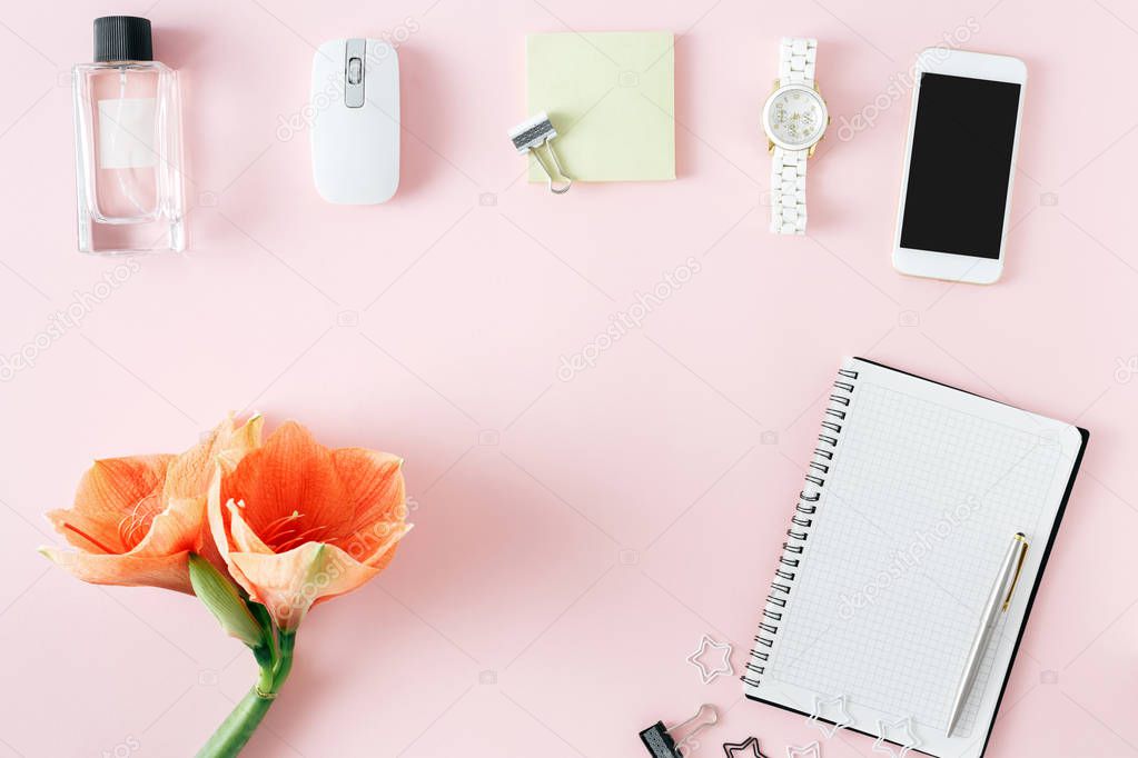 frame from flowers amaryllis, notebook, smartphone, wristwatch, computer mouse and perfume flowers