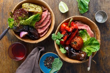 Ahşap masa, üstten görünüm tabaklarda ekmek ızgara biftek ızgara sebzeler ile servis