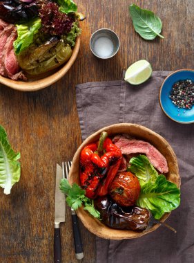 Ahşap masa, üstten görünüm tabaklarda ekmek ızgara biftek ızgara sebzeler ile servis