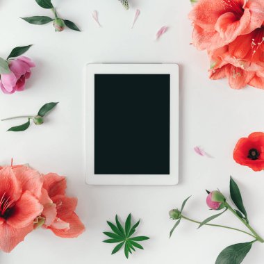 Tablet pc ile boş bir ekran ve beyaz arka plan üzerinde üstten görünüm izole çiçekler