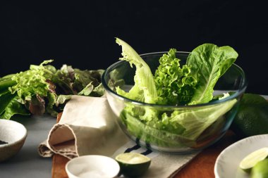 Marul siyah arka plan, sağlıklı gıda kavramı üzerine yeşil salata ile büyük cam kase 