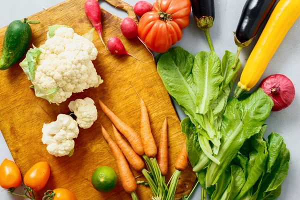 Gri arka plan üzerinde sağlıklı yemekler pişirmek için çiğ sebze kümesi