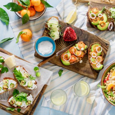 Vejetaryen yemekleri Ev yapımı limonata mavi ahşap tablo kümesi. Bruschetta domates, salatalık, Brüksel lahanası ve nohut ve mavi ahşap masa üzerinde quinoa salata ile üst görünüm. Vejetaryen yiyecekler kavramı