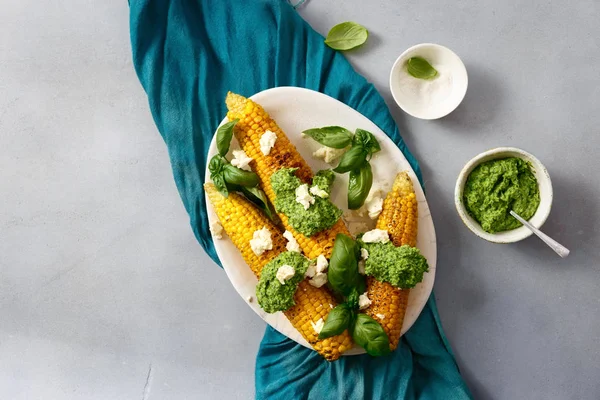 Üstten görünüm tatlı kızarmış Mısır gri arka plan üstten görünüm fesleğen sos ve beyaz peynir ile