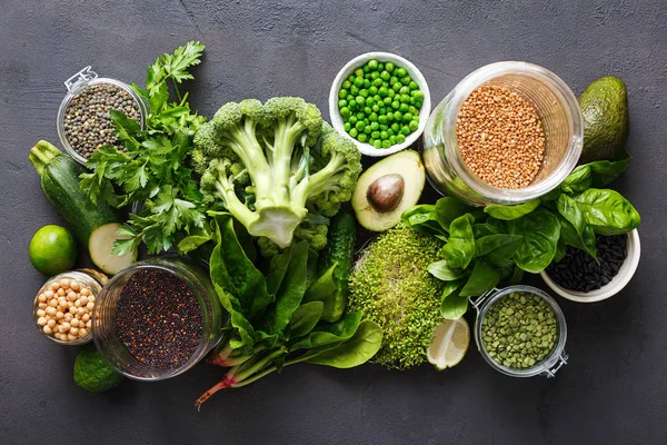 Set raw vegetables and grain products source of protein for vegetarians: cucumber, lucerne, zucchini, spinach, basil, green peas, avocado, broccoli, lime, buckwheat, green lentils, chickpea and quinoa on black background, top view — Stock Image Set Raw Vegetables Grain Products Source Protein Vegetarians Cucumber Lucerne Stock Image