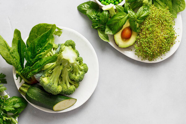 Top view Healthy food clean eating selection source of protein for vegetarians: avocado, zucchini, green peas and broccoli on gray concrete background