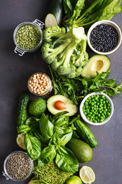 Temiz bir protein kaynağı için vejetaryen yemek ayarla çiğ sağlıklı gıda: salatalık, lucerne, kabak, ıspanak, fesleğen, yeşil bezelye, avokado, brokoli, kireç, siyah fasulye ve siyah arka plan, üstten görünüm üzerinde yeşil mercimek