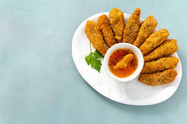 Kopyalama alanı üst mavi zemin üzerine ekşi-tatlı soslu tavuk göğsü nuggets görüntülemek 