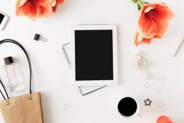 Ofis tablo masası ile tablet, defter, kalem, çiçek nergis zambağı, akıllı telefon, kahve fincanı, çanta, kol saati ve parfüm, sosyal medya.