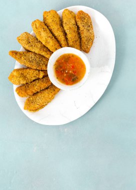 Kopyalama alanı üst mavi zemin üzerine ekşi-tatlı soslu tavuk göğsü nuggets görüntülemek 