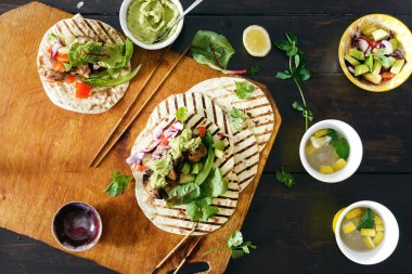 Yemek masası ile tacos ızgara sebze salsa, guacamole sos, tavuk ve limonata üstten görünüm 