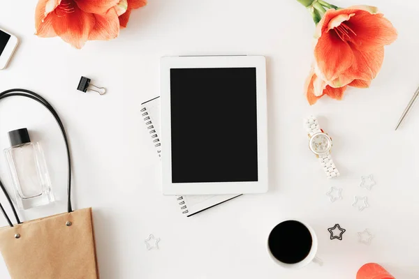 Ofis tablo masası ile tablet, defter, kalem, çiçek nergis zambağı, akıllı telefon, kahve fincanı, çanta, kol saati ve parfüm, sosyal medya.