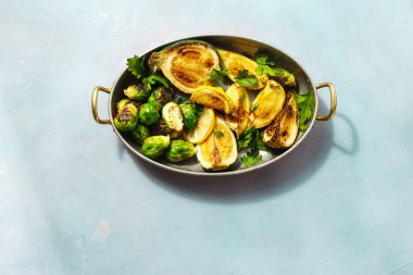 Düz kızarmış kabak kızartma tavası mavi taş zemin sağlıklı vejetaryen yemek üstten görünüm üzerine servis ile Brüksel lahanası göklere