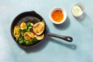 Sağlıklı vejetaryen yemek Fried Brüksel lahanası mavi taş zemin üstüne dökme demir tavada servis kabak ile göster