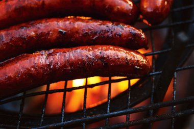 Izgara sosis ızgara alevler ile. Barbekü arka plan