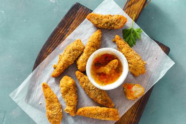 Ahşap tahta üzerinde mavi arka plan üstten görünüm üzerinde ekşi-tatlı sos ile servis tavuk göğsü nuggets 