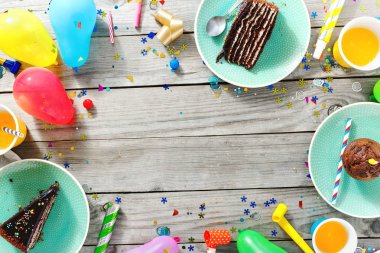 Üstten görünüm çocuk şenlikli arka plan. Çerçeve ahşap zemin düz üzerine çikolatalı pasta, kek ve dekorasyon parti yatıyordu