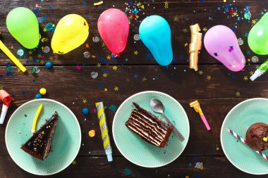 Çikolatalı kek ve dekorasyon parti kahverengi ahşap arka plan düz üzerinde yatıyordu. Üstten görünüm Çocuk Doğum günü tablo kavramı