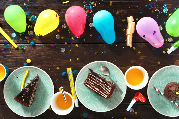 查看儿童生日表的概念 巧克力蛋糕和装饰党在棕色木桌平躺 — 图库照片