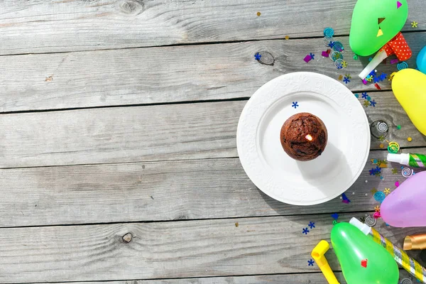 查看儿童生日表的概念 巧克力松饼蜡烛和装饰党在木质背景与复制空间平躺 — 图库照片