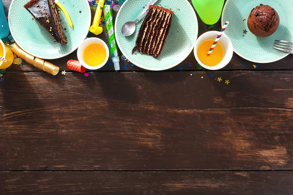 查看儿童生日表的概念 巧克力蛋糕和装饰党在褐色木质背景与拷贝空间平的放置 — 图库照片