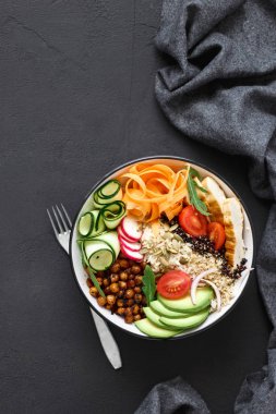 Buda kase. Temiz ve dengeli sağlıklı gıda kavramı. Tavuk ızgara biftek, pirinç, baharatlı nohut, siyah ve beyaz quinoa, avokado, havuç, kabak, turp, domates kopya alanı, üstten görünüm ile koyu arka plan üzerinde