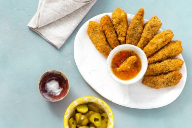 Üstten görünüm tavuk göğsü nuggets mavi zemin üzerine ekşi-tatlı sos ile